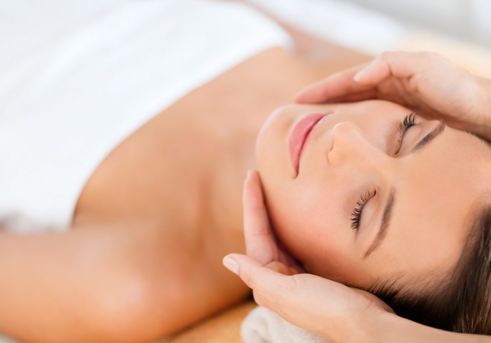 health, beauty, people and relaxation concept - beautiful woman in spa salon getting face treatment